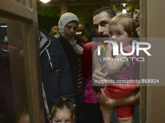 Families of refugees awaiting to enter to the Aspa Boomerang Restaurant, as the owner Michael Pastrikos, helped by his family members, his s...