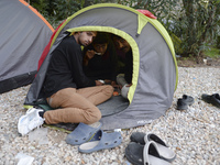 Three migrants from Pakistan having an evening meal in their small tant, near the main Police station in Kos Town, as hundreds of new arrive...
