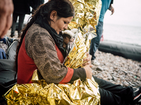 A women wraps her child in a thermal blanket after arriving on the shores of Lesbos, Greece, on September 28, 2015. More than 700,000 refuge...