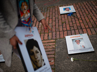 A relative carries a photo of their family member victim of enforced disappearances during the framework of the International Day of the Vic...