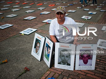 Dania Arroyave Bonilla, poses with the portraits of Pedro Nel Arroyave, her father and her siblings all victims of forced dissapearances dur...