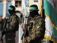 Members of the Ezzedine al-Qassam Brigades, the military wing of the Palestinian Islamist movement Hamas, attend a memorial to a model of 