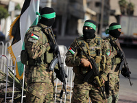 Members of the Ezzedine al-Qassam Brigades, the military wing of the Palestinian Islamist movement Hamas, attend a memorial to a model of 