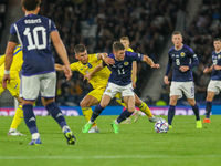 Ryan Christie of Scotland tries to avoid the challenge from Ruslan Malinovskyi of Ukraine during the UEFA Nations League match between Scotl...