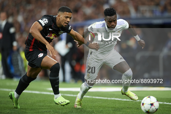 Vinicius Junior left winger of Real Madrid and Brazil and Benjamin Henrichs right-back of RB Leipzig and Germany compete for the ball during...