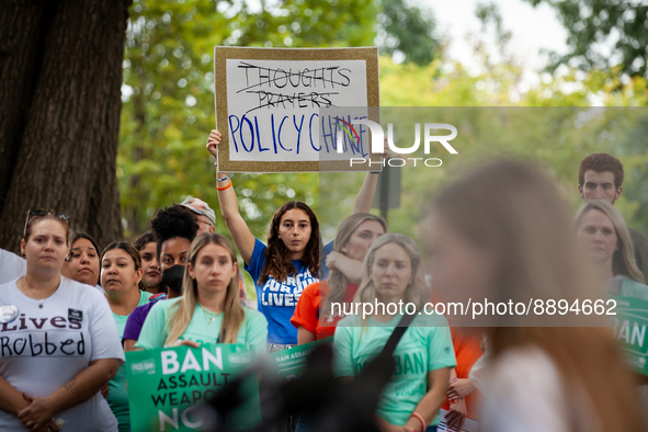 A demonstrator isplays a sign calling for policy change intead of 