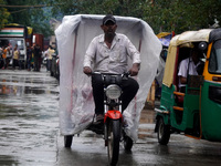 A man rides his battery rickshaw covered with a plastic sheet during a spell of rain in New Delhi, India on September 22, 2022.  (