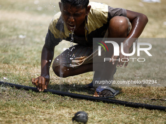 A boy drinking water from water pipe while playing on field.
People in the capital experienced the hottest day in the last 54 years as the m...
