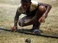 A boy drinking water from water pipe while playing on field.
People in the capital experienced the hottest day in the last 54 years as the m...
