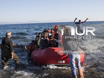 Migrants riding a dinghy reach the shores of the Greek island of Lesbos after crossing the Aegean Sea from Turkey on November 13, 2015. (