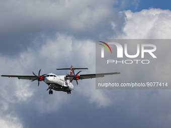 Loganair ATR 72 turboprop aircraft as seen on final approach flying over the houses of Myrtle avenue in London, a famous location for plane...