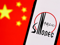 Sinopec logo displayed on a phone screen and Chinese flag displayed on a screen in the background are seen in this illustration photo taken...