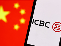 Industrial and Commercial Bank of China logo displayed on a phone screen and Chinese flag displayed on a screen in the background are seen i...