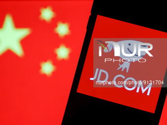 JD.com logo displayed on a phone screen and Chinese flag displayed on a screen in the background are seen in this illustration photo taken i...