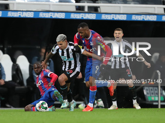 Newcastle United's Bruno Guimaraes battles for possession with Crystal Palace's Tyrick Mitchell and Jordan Ayew during the Carabao Cup Third...