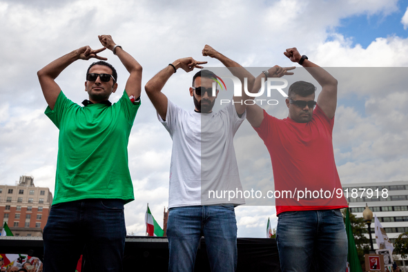 Three men dressed in the colors of Iran's flag pose for photos at a rally and march for Mahsa (Zhina) Amini and those protesting her death i...