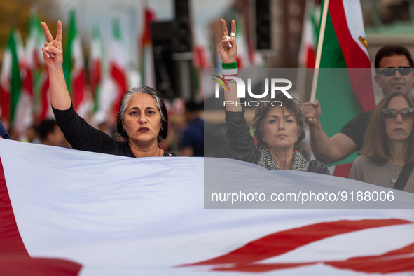 People carry a giant Iranian flag while marching for Mahsa (Zhina) Amini those people protesting her death in Iran.  After the really, peopl...