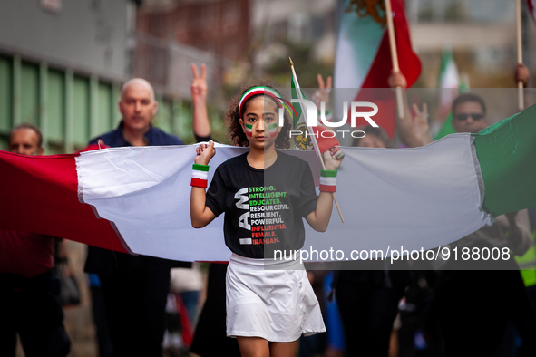 A girl leads the way with a giant Iranian flag during a march for Mahsa (Zhina) Amini and people protesting her death in Iran.  After the re...