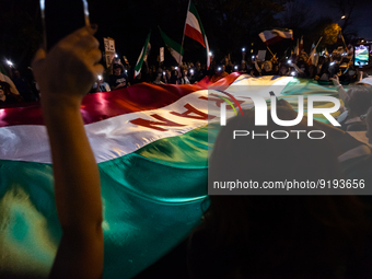 Demonstrators sing around an Iranian flag at the conclusion of a march for Mahsa (Zhina) Amini and those protesting her death in Iran.  Afte...