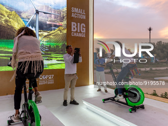Visitors use bicycles to generate energy in the evening in the Green Zone of the COP27 UN Climate Change Conference, held by UNFCCC in Sharm...