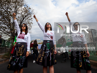 Arghavan, Roji,and Nadia (left to right) walk at the head of a march for Mahsa (Zhina) Amini and people protesting her death in Iran.  After...