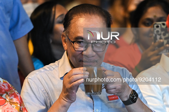 Malaysian opposition leader Anwar Ibrahim takes a sip of milk coffee before addressing to the people during an election campaign ahead of Ma...