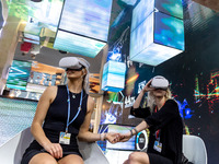 Women watch 3D recording in the Brasilian Pavilion during the COP27 UN Climate Change Conference, held by UNFCCC in Sharm El-Sheikh Internat...