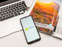 In this photo illustration a S7 airlines logo seen displayed on a smartphone screen on a desk next to a Macbook and atravel magazine in Athe...