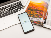 In this photo illustration a South African airlines logo seen displayed on a smartphone screen on a desk next to a Macbook and atravel magaz...