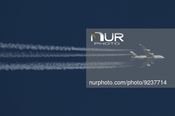 Emirates Airbus A380 double decker passenger aircraft as seen flying in the blue sky over the Netherlands in Europe, the route EK22 from Man...