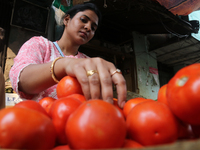 A women seller sorts tomatoes in a vegetable market in Kolkata,India,Wednesday,Nov.23,2022. (