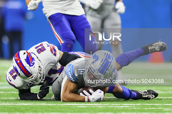 Detroit Lions wide receiver Amon-Ra St. Brown (14) is tackled by Buffalo Bills safety Jordan Poyer (21) during an NFL football game between...