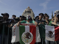Two people hold a Mexican flag during the FIFA Fan Fest Mexico on the esplanade of the Monumento a la Revolución in Mexico City, on the occa...