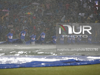 Sri Lankan ground staff brings in covers as it rains during the second one-day international cricket match between Sri Lanka and Afghanistan...
