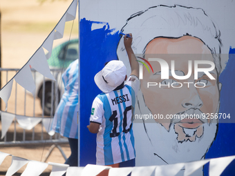 A boy works on a painting depicting Lionel Messi at a Fan Fest before the match between Argentina and Mexico at the World Cup, hosted by Qat...