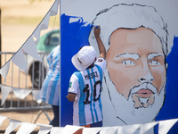 A boy works on a painting depicting Lionel Messi at a Fan Fest before the match between Argentina and Mexico at the World Cup, hosted by Qat...
