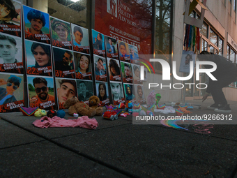 A person adds items to a memorial to children killed in Iran outside of UNICEF USA's Mid-Atlantic Regional Office in Washington, D.C. on Nov...