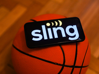 Sling TV logo displayed on a phone screen and a basketball are seen in this illustration photo taken in Krakow, Poland on December 1, 2022....