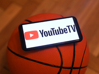 YouTube TV logo displayed on a phone screen and a basketball are seen in this illustration photo taken in Krakow, Poland on December 1, 2022...