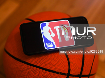 NBA TV logo displayed on a phone screen and a basketball are seen in this illustration photo taken in Krakow, Poland on December 1, 2022. (
