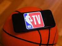 NBA TV logo displayed on a phone screen and a basketball are seen in this illustration photo taken in Krakow, Poland on December 1, 2022. (
