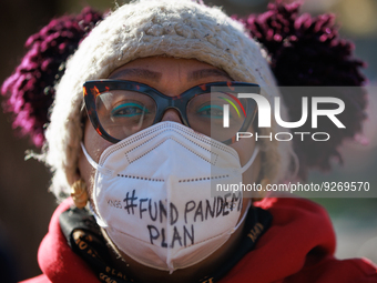 A demonstrator wears a mask with writing reading '#fund pandemic plan' during a protest outside of the White House in Washington, D.C. on Wo...