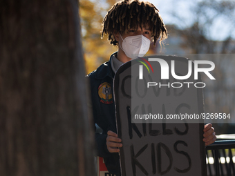 A demonstrator holds a sign reading 'COVID kills kids' outside of the White House in Washington, D.C. on World AIDS Day, December 1, 2022 du...