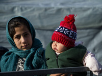 A Syrian mother, along with her baby eight months ago the row to take winter clothes, provided by volunteers from the refugee camp in Sentil...