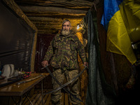 A soldier of a cossack battalion shows a couple of the ceremonial swords in the underground base of his unit near the frontlines of Zaporizh...