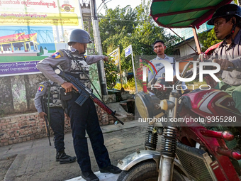 Armed policemen inspect a tricycle at a roadside checkpoint during the visit of the Myanmar junta leader Min Aung Hlaing to Thanlyin townshi...