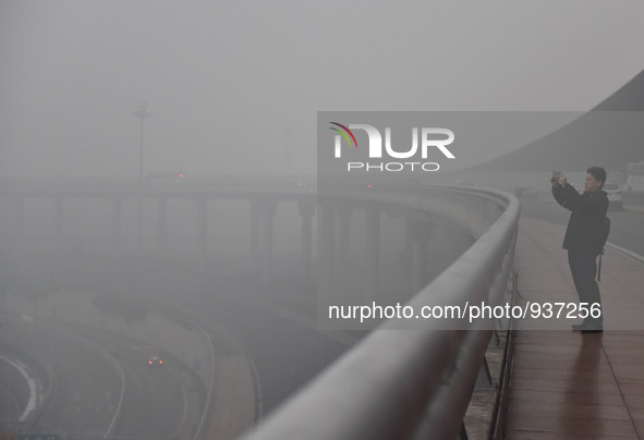 (151201) -- BEIJING, Dec. 1, 2015 () -- A man takes photos of the fog at Capital International Airport in Beijing, capital of China, Dec. 1,...