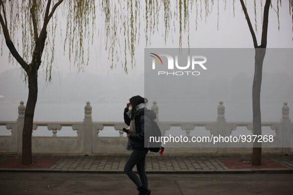 (151201) -- BEIJING, Dec. 1, 2015 () -- A girl wearing respirator walks at Shichahai in Beijing, capital of China, Dec. 1, 2015. Heavy fog h...
