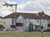 China Eastern Airlines Airbus A330 aircraft as seen on final approach flying over the houses of Myrtle avenue in London and a girl jumping a...