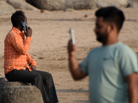 People uses smartphone near a sea beach in Mumbai, India, 04 January, 2023. Smartphone flattens internet growth curve in India according to...